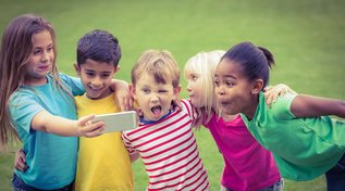 Fünf Kinder die mit einem Smartphone ein Foto von sich machen. (Quelle: © WavebreakmediaMicro / Fotolia.com) Fünf Kinder die mit einem Smartphone ein Foto von sich machen.