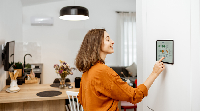 Eine Frau bedient ihren Bildschirm für das Smart home in ihrer Küche (Quelle: © rh2010 / Adobe Stock) Eine Frau bedient ihren Bildschirm für das Smart home in ihrer Küche
