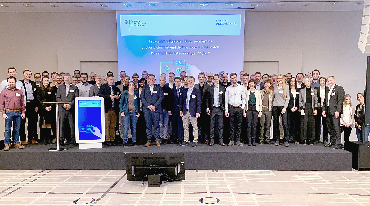 Auftaktveranstaltung zum Förderprogramm "Cyber-Sicherheit und digitale Souveränität in den Kommunikationstechnologien 5G/6G". Die Teilnehmenden auf der Bühne. (Quelle: BSI) Auftaktveranstaltung zum Förderprogramm "Cyber-Sicherheit und digitale Souveränität in den Kommunikationstechnologien 5G/6G". Die Teilnehmenden auf der Bühne.