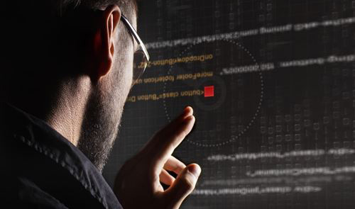 Ein Mann schaut auf einen Monitor und überprüft den Text (Quelle: © Glebstock / Fotolia.com) Ein Mann schaut auf einen Monitor und überprüft den Text