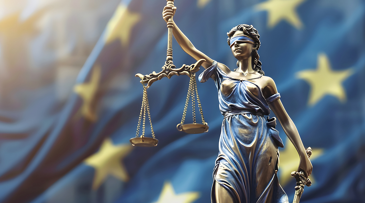 Justitia vor der Europa-Flagge (Quelle: © dinny / Adobe Stock) Justitia vor der Europa-Flagge